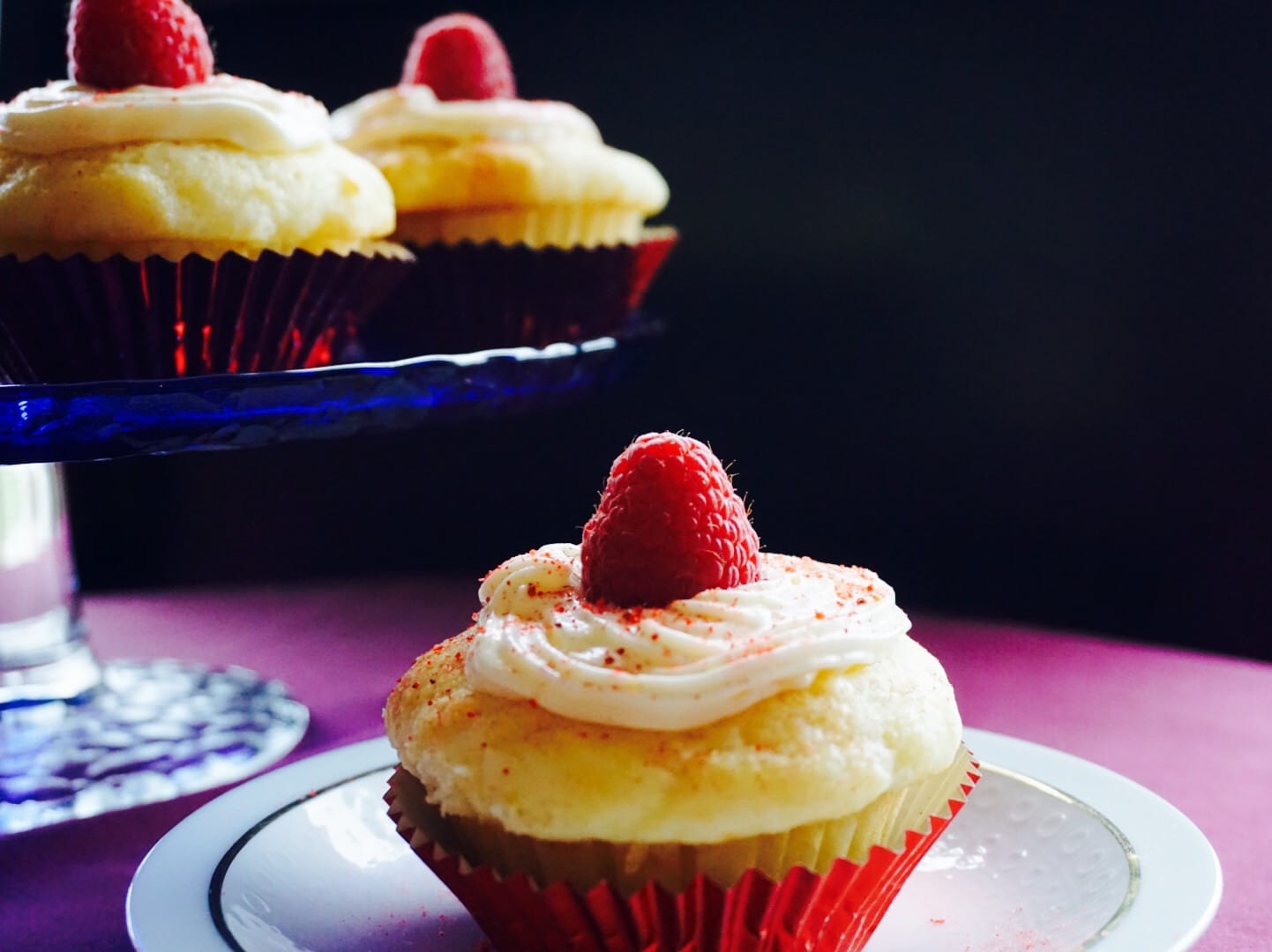 Lemon ricotta cupcakes topped with a little light lemon cream cheese frosting, raspberry fairy dust (crushed freeze dried raspberries) and topped with a raspberry