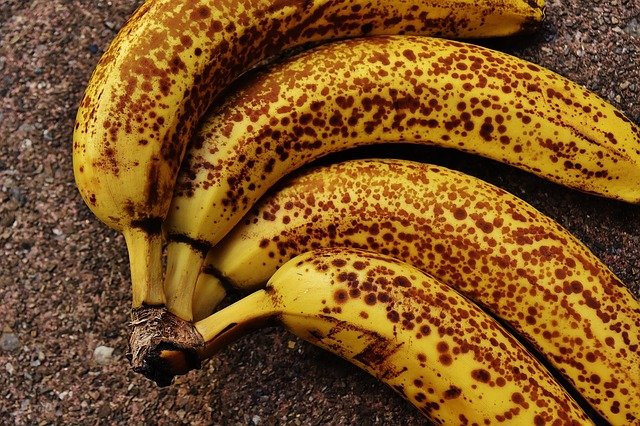 Four very ripe bananas with brown spots.